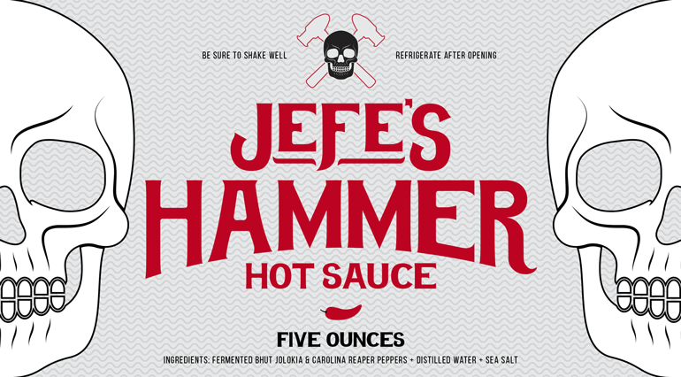 Sauce bottle grey label with red logo text centered, and white skull halves on the left and right